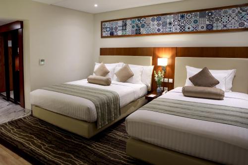 木爾坦的住宿－Avari Boutique Multan，一间酒店客房,房间内设有两张床