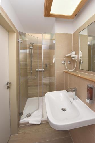 a bathroom with a sink and a shower at Port Inn Hotel in Eichwalde