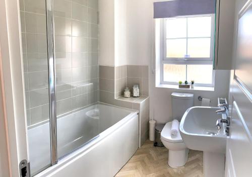 uma casa de banho com uma banheira, um WC e um lavatório. em Home Crowd Luxury Apartments- Auckley House em Doncaster