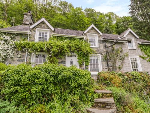 an old stone house with bushes in front of it at Llety Perygl in Harlech