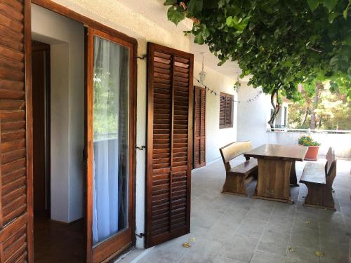 a patio with a table and a wooden door at Apartment Bura in Šibenik