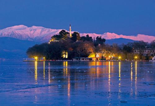 a large body of water with mountains in the background at Stalaktites in Ioannina