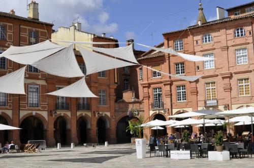 a group of white umbrellas in front of a building at Le bon'appart - 50m de la cathédrale in Montauban