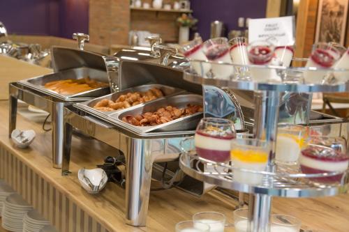 a buffet line with trays of food and drinks at Iveria Inn Hotel in Tbilisi City