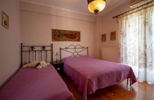 two beds in a bedroom with purple sheets at Laconian Collection #Karvela's stone house# in Karvelás