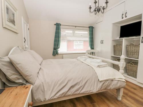 a bedroom with a bed and a window at Benjamin Cottage in Redcar