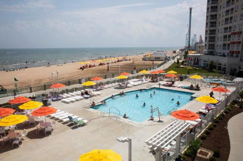 a swimming pool with umbrellas and a beach at Cedar Point Hotel Breakers in Sandusky