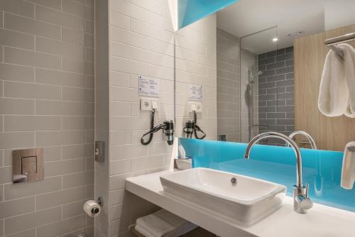 La salle de bains est pourvue d'un lavabo et d'un miroir. dans l'établissement Holiday Inn Express - Siegen, an IHG Hotel, à Siegen