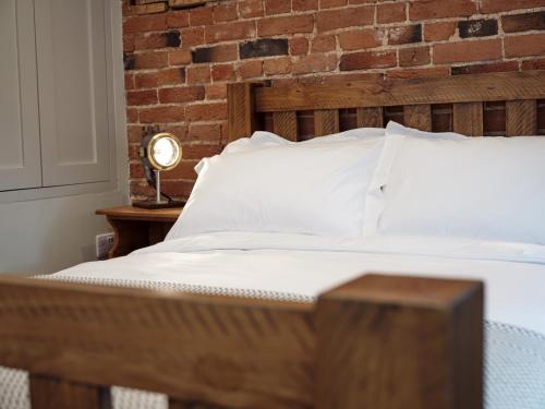 a bedroom with a bed with a brick wall at 67 Bridge End in Warwick