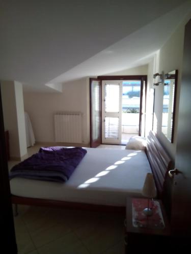 a large bed in a room with a window at Attico Mansardato e Climatizzato con vista Mare in Montesilvano