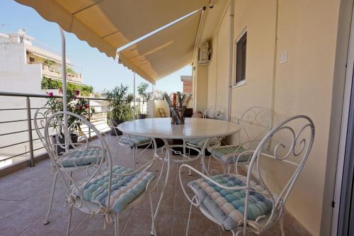 a patio with a table and chairs on a balcony at Athens Central Apartment 2 mins to metro in Athens