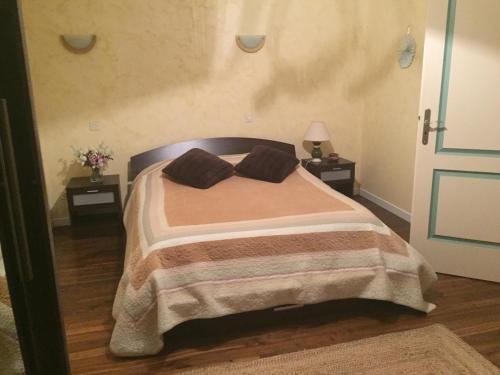 a bedroom with a bed with two pillows on it at Chambre chez l'habitant dans Jolie maison de campagne in Céaux-en-Couhé