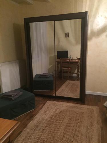 einen Spiegel in einem Zimmer mit einem Tisch und einem Schreibtisch in der Unterkunft Chambre chez l'habitant dans Jolie maison de campagne in Céaux-en-Couhé