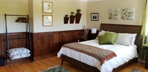 a bedroom with a bed with white sheets and green pillows at Trinity Guest House in Trinity