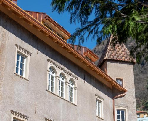 a building with white windows and a roof at Castel Hörtenberg in Bolzano