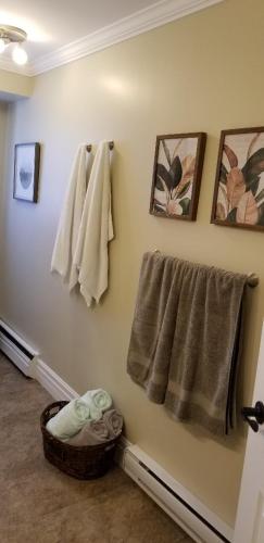 a bathroom with towels hanging on a wall at Trinity Guest House in Trinity