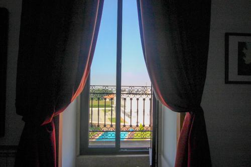 a window with curtains and a view of a pool at Quinta da Aldeia de Avanca in Avanca