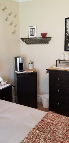 a bedroom with a bed and a kitchen with a sink at Trinity Guest House in Trinity