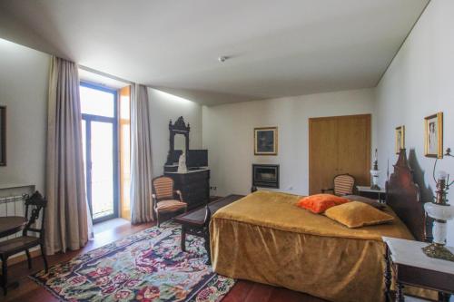 um quarto com uma cama grande e uma janela grande em Quinta da Aldeia de Avanca em Avanca