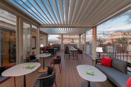 a restaurant with tables and chairs on a balcony at Hotel Nord Nuova Roma in Rome