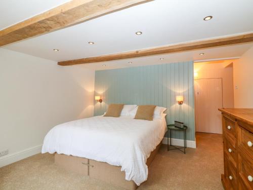 a bedroom with a bed and a blue wall at River Cottage Hayfield in Highpeak Junction