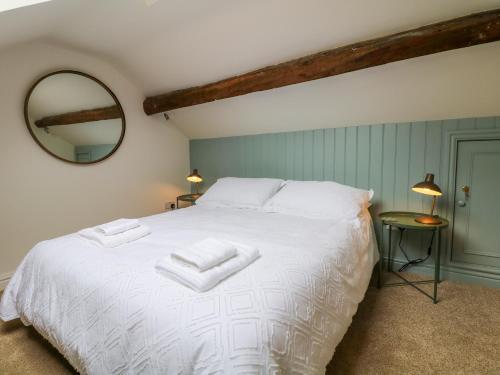 a bedroom with a white bed with two towels on it at River Cottage Hayfield in Highpeak Junction