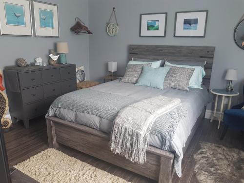 a bedroom with a large bed and a dresser at Trinity Guest House in Trinity