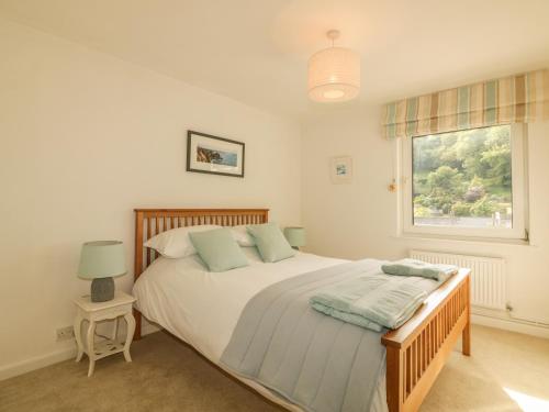 een slaapkamer met een bed en een raam bij Kittiwake in Plymouth