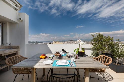 una mesa de madera en el balcón de una casa en GB Athens View Luxury Suite, en Atenas