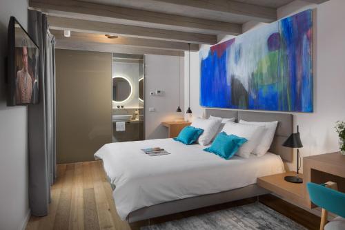 una camera da letto con un grande letto bianco con cuscini blu di Luxury Town House Corto Bechera a Bale (Valle)