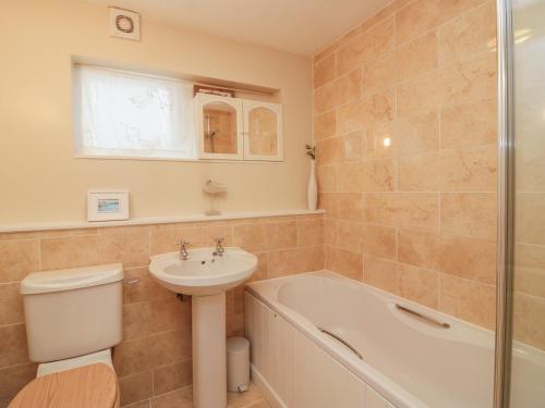 een badkamer met een wastafel, een toilet en een ligbad bij Kittiwake in Plymouth