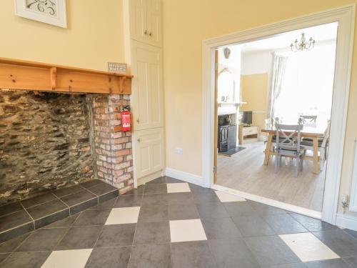 a living room with a stone fireplace and a dining room at Angorfa in Llanbedr