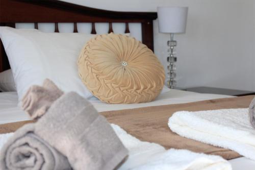 a bed with a pillow and towels on it at The Muize in Muizenberg