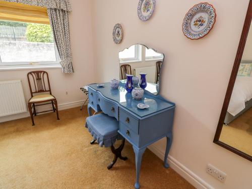 a blue dressing table in a room with a mirror at Sevenacres in Kelso