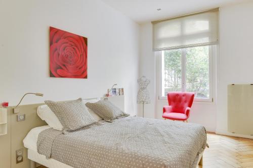 une chambre avec un lit et une chaise rouge dans l'établissement PERE LACHAISE - MONTMARTRE Paris centre, à Paris