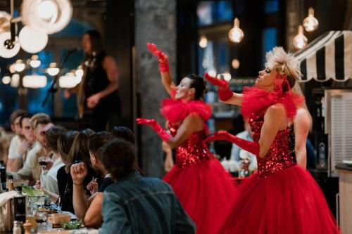 two women in red dresses dancing in front of a crowd at La Folie Douce Hotels Chamonix in Chamonix