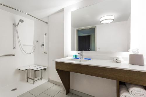 uma casa de banho branca com um lavatório e um chuveiro em Holiday Inn Express - Lorton, an IHG Hotel em Lorton