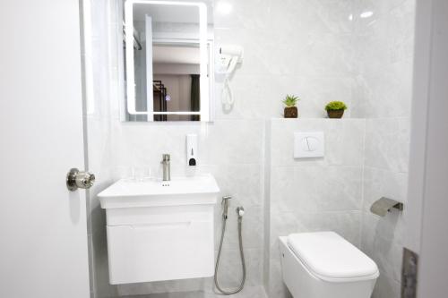 a bathroom with a toilet and a sink and a mirror at Graphica Tbilisi Hotel in Tbilisi City