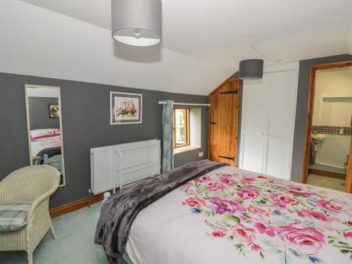 a bedroom with a large bed with a floral bedspread at Cottage on the Common in Westbury on Severn