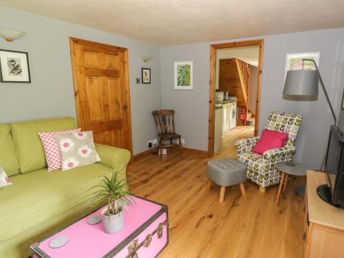 a living room with a couch and a chair at Cottage on the Common in Westbury on Severn