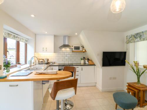 a kitchen with a sink and a table and chairs at Woodstock Retreat in Axminster