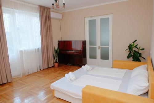 a bedroom with a white bed and a piano at Keti&Tatia Sisters Apartment - near Old and Central Tbilisi in Tbilisi City