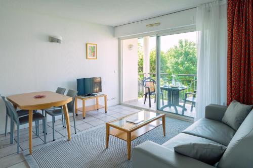 een woonkamer met een bank en een tafel bij Résidence Biarritz Ocean in Biarritz