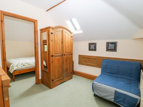 a bedroom with a blue bed and a mirror at Barn Owl in Louth