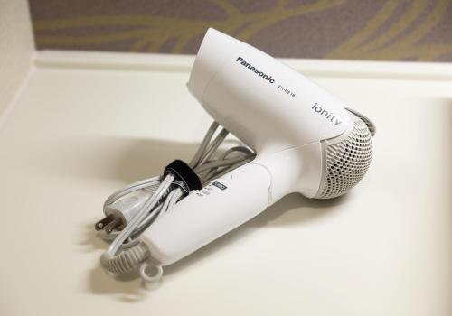 a white hair dryer sitting on top of a counter at HOTEL PROMOTE HIROSHIMA in Hiroshima