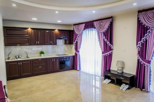 eine Küche mit lila Vorhängen und einem Waschbecken in der Unterkunft Palace in Uman