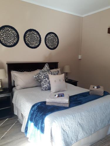 a bedroom with a bed with a blue blanket and pillows at KIHARA GUESTHOUSE in Bethlehem