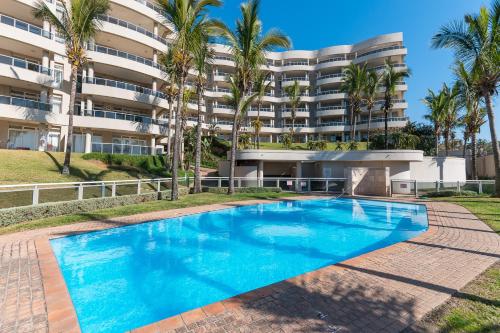 a swimming pool in front of a building at Ballito Manor - Manor View 102 in Ballito