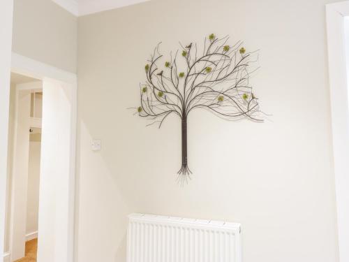 a metal tree on the wall in a room at Gate Lodge in West Calder