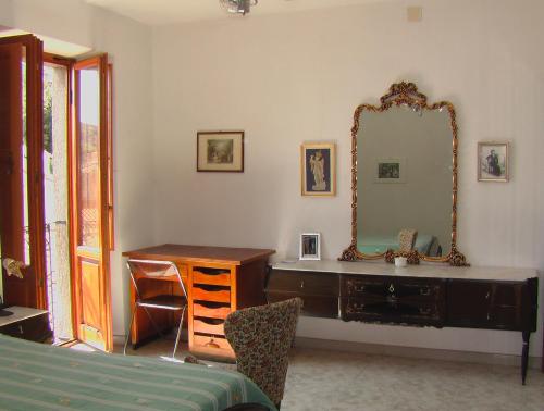 ein Schlafzimmer mit einer Kommode und einem Spiegel an der Wand in der Unterkunft ALLOGGIO CASA IN PIETRA in Santu Lussurgiu